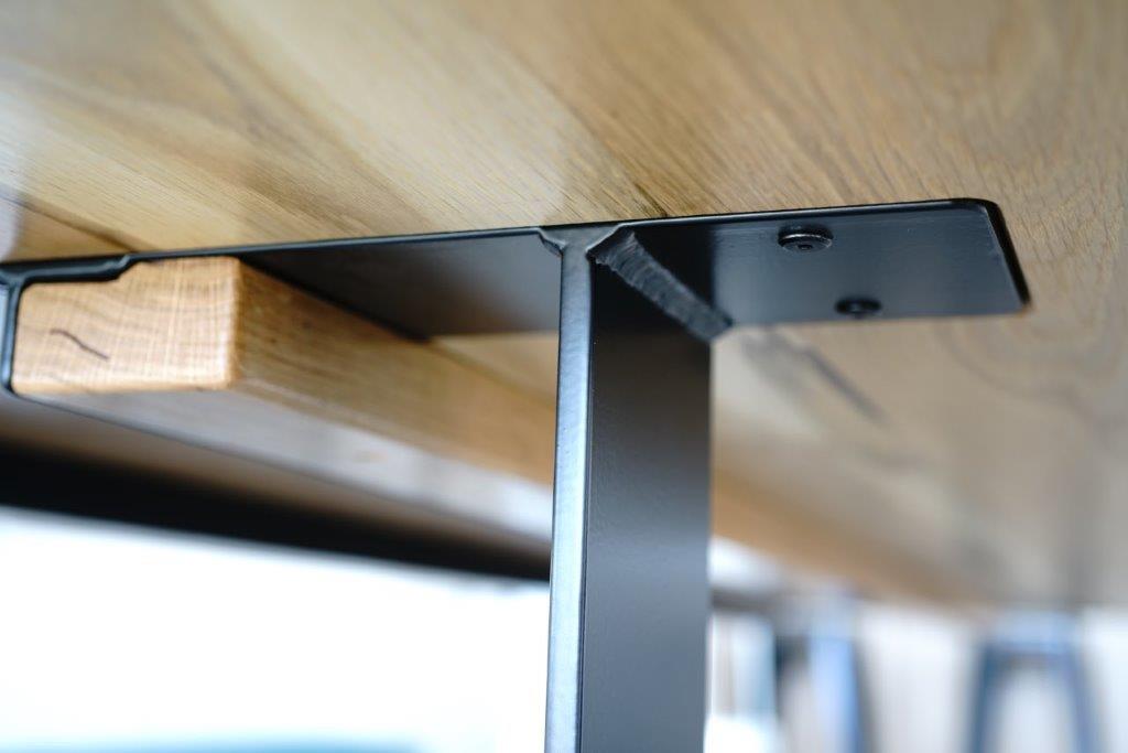 Close-up view of a Timber Grooves American White Oak Dining Table with a black steel table base, showcasing the elegance of handcrafted dining room furniture.